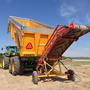 ... en op het land worden de aardappelen weer gelost in de pootmachine.