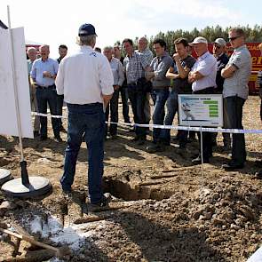 Een groep akkerbouwers luistert op het land naar een uiteenzetting over bandenspanning en de breedte van banden. Met een profielkuil laat Michelin zien dat het effect van de grotere voetprint (bredere band) op de insporing positief is. Verder blijkt dat n