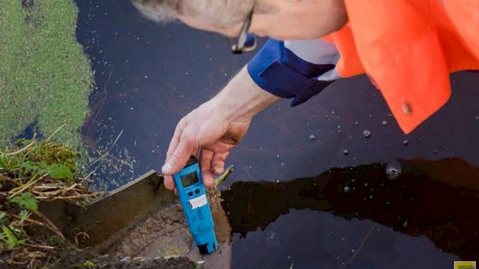 Voor een meting van uitstromende zouten vanaf een varkensbedrijf, steekt Boom een zogeheten geleidbaarheidsmeter in de uitstroomvoorziening. De gemeten waarde van 1.800 mS (microsiemens) valt binnen de toegestane norm.