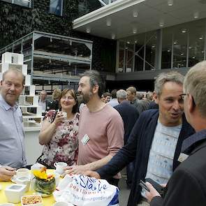 De eerste bezoekers kletsen gezellig bij voordat de eerste presentaties beginnen.