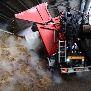 Het lossen van de paardenmest in de loods met een zijkipper. Paardenmest is stro met bacteriologisch leven dat goed is voor het verkorten van het fermentatieproces.