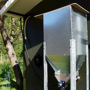 Aan de buitenkant een silo voor het voer. Een biologisch groeivoer. Een deel van het dagelijks rantsoen komt niet naar de hanen toe maar ze gaan zelf op zoek naar torretjes, spinnen en kruiden buiten in de Mortelen op gronden van het Brabants Landschap.