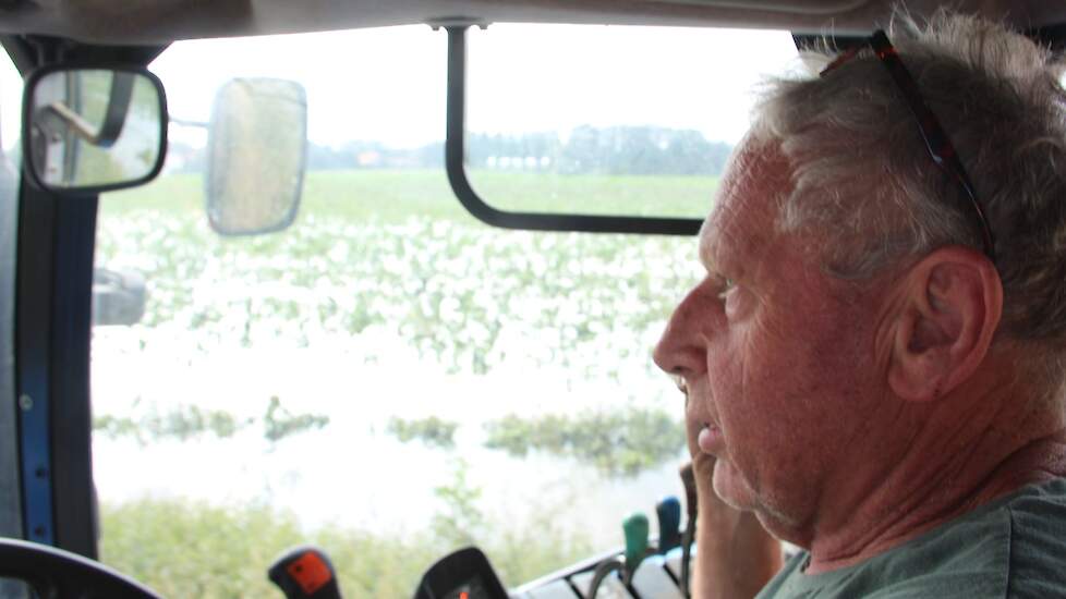 Op zijn New Holland rijdt Wim van de Eertwegh door het Maaswater langs enkele van de getroffen percelen. Los van de actuele overstromingen is Van de Eertwegh erg te spreken over de locatie waar zijn bedrijf is gevestigd. „Hier langs de Maas beschikken we