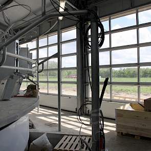 Door drie grote roldeuren valt ook onder het melken te genieten van licht en uitzicht op de toerit. 's Zomers kunnen deze deuren open voor goede ventilatie.