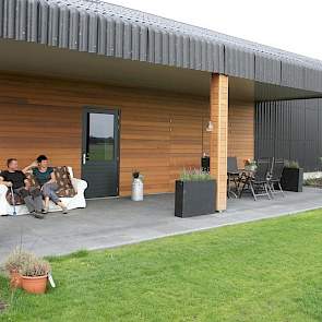 De achterkant van de werktuigenberging vormt een prachtige veranda bij de tuin. Dit vormt ook de entree van de speciale ruimte voor boerderij-educatie, naast de ruimte in de stal boven de robots.